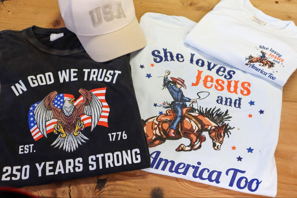 Two t-shirts with graphics on a wooden surface.