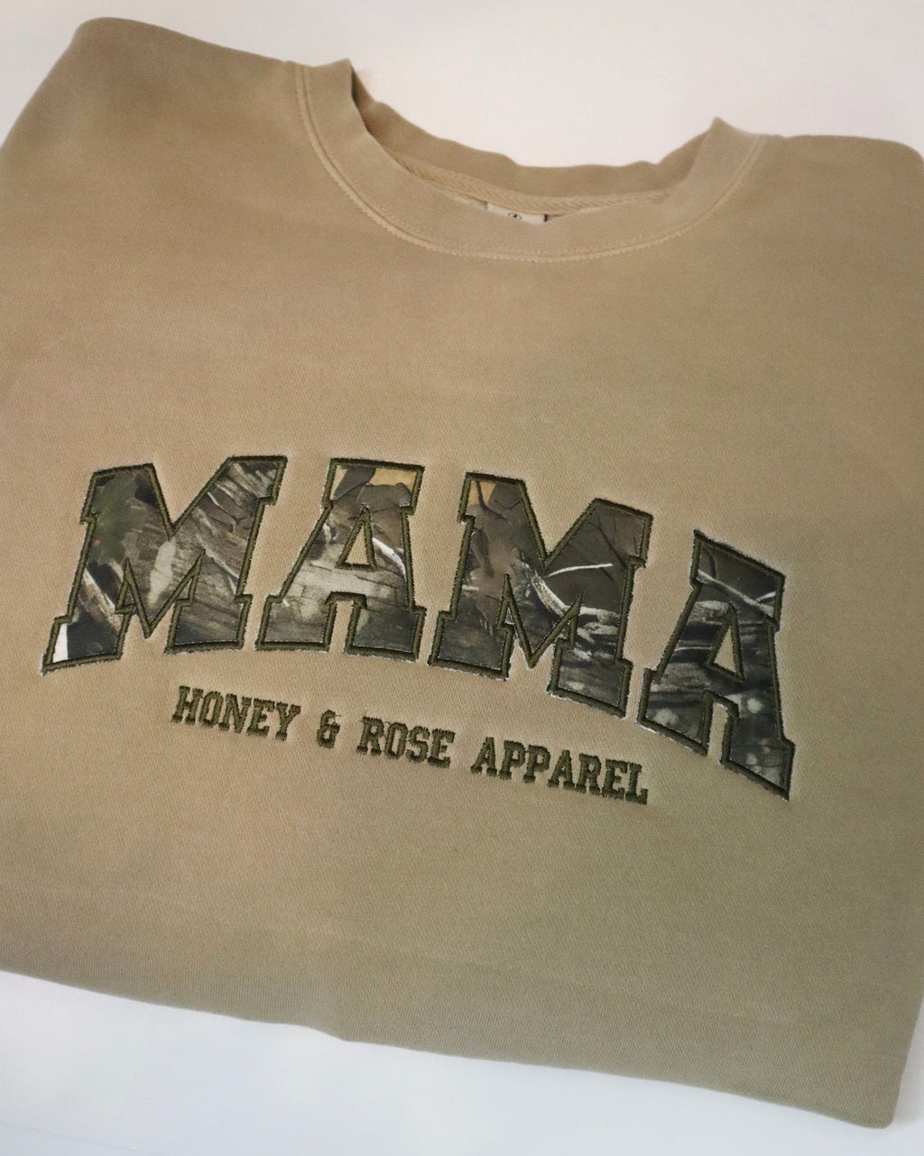 Beige sweatshirt with 'MAMA' and 'Honey & Rose Apparel' text on a white background